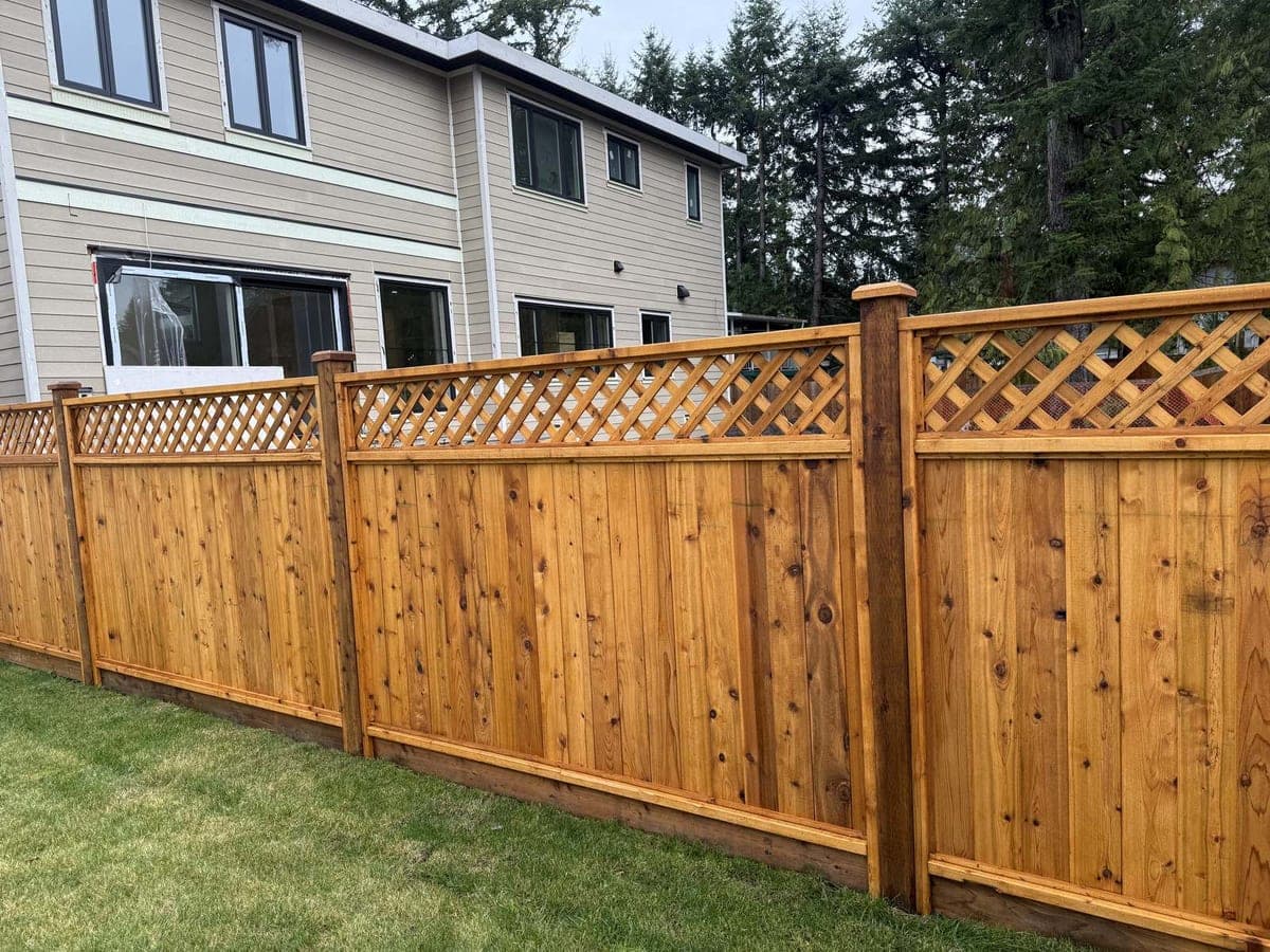 Stained cedar privacy fence with diagonal lattice top enclosing a backyard