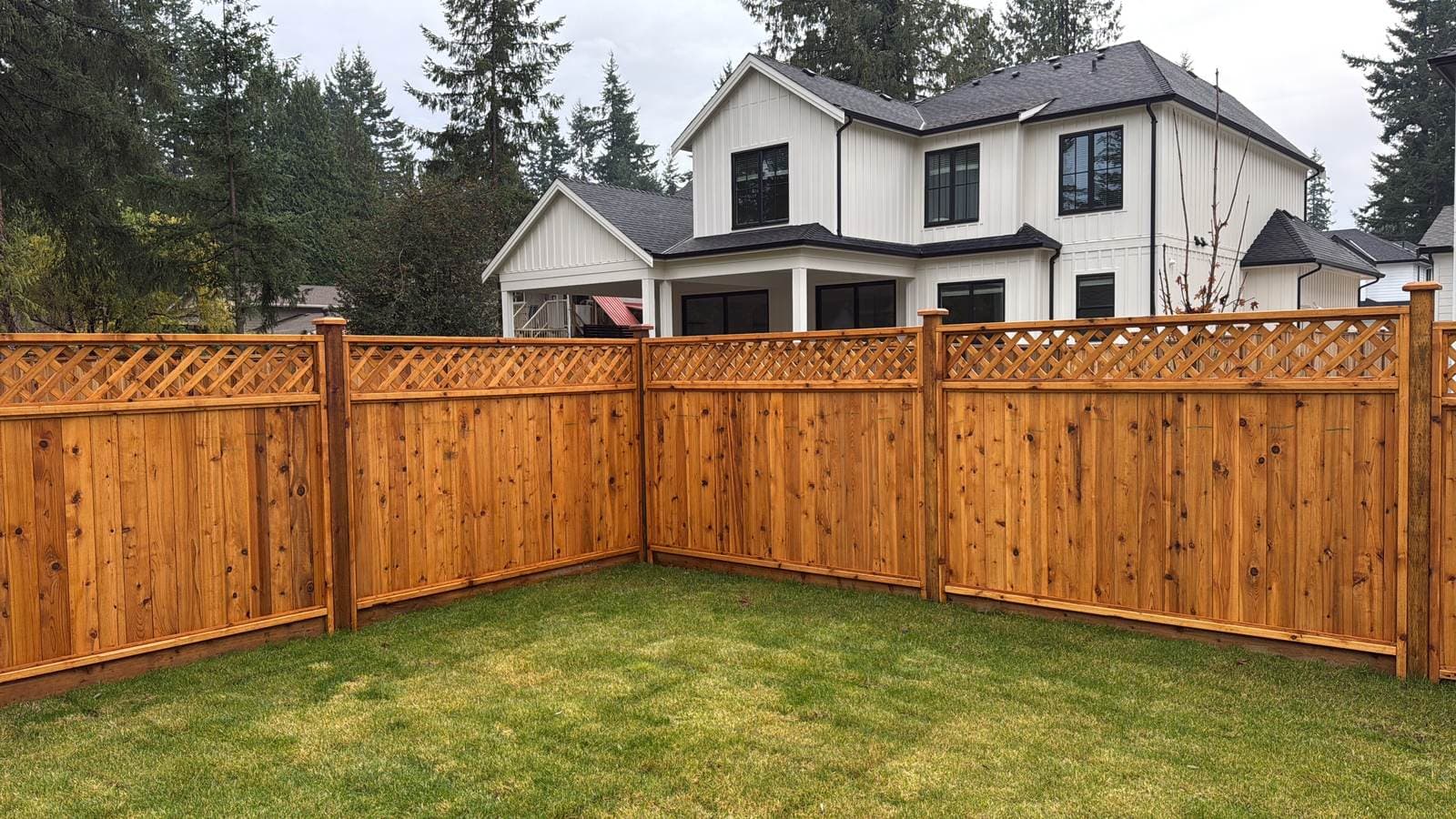 Cedar lattice-top fence panels around the corner of a backyard