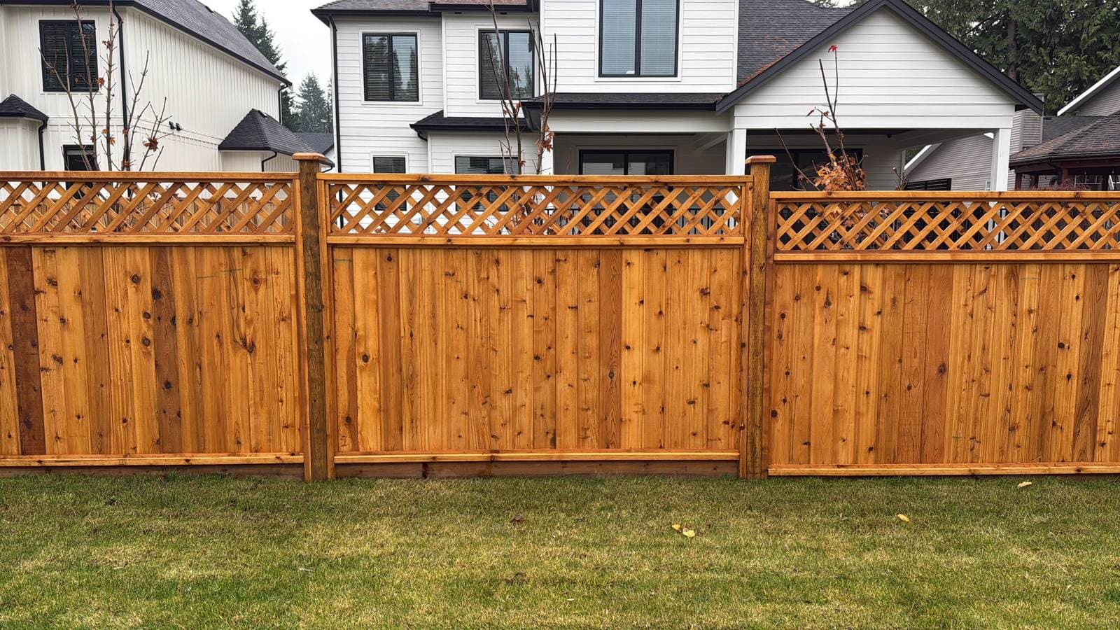 Straight run of cedar privacy fence panels with diagonal lattice tops