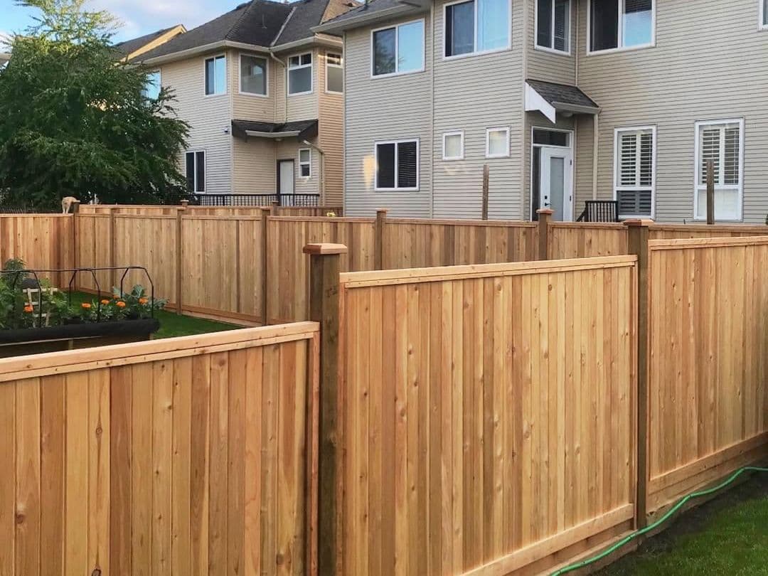 Natural cedar full-privacy fence around a backyard vegetable garden
