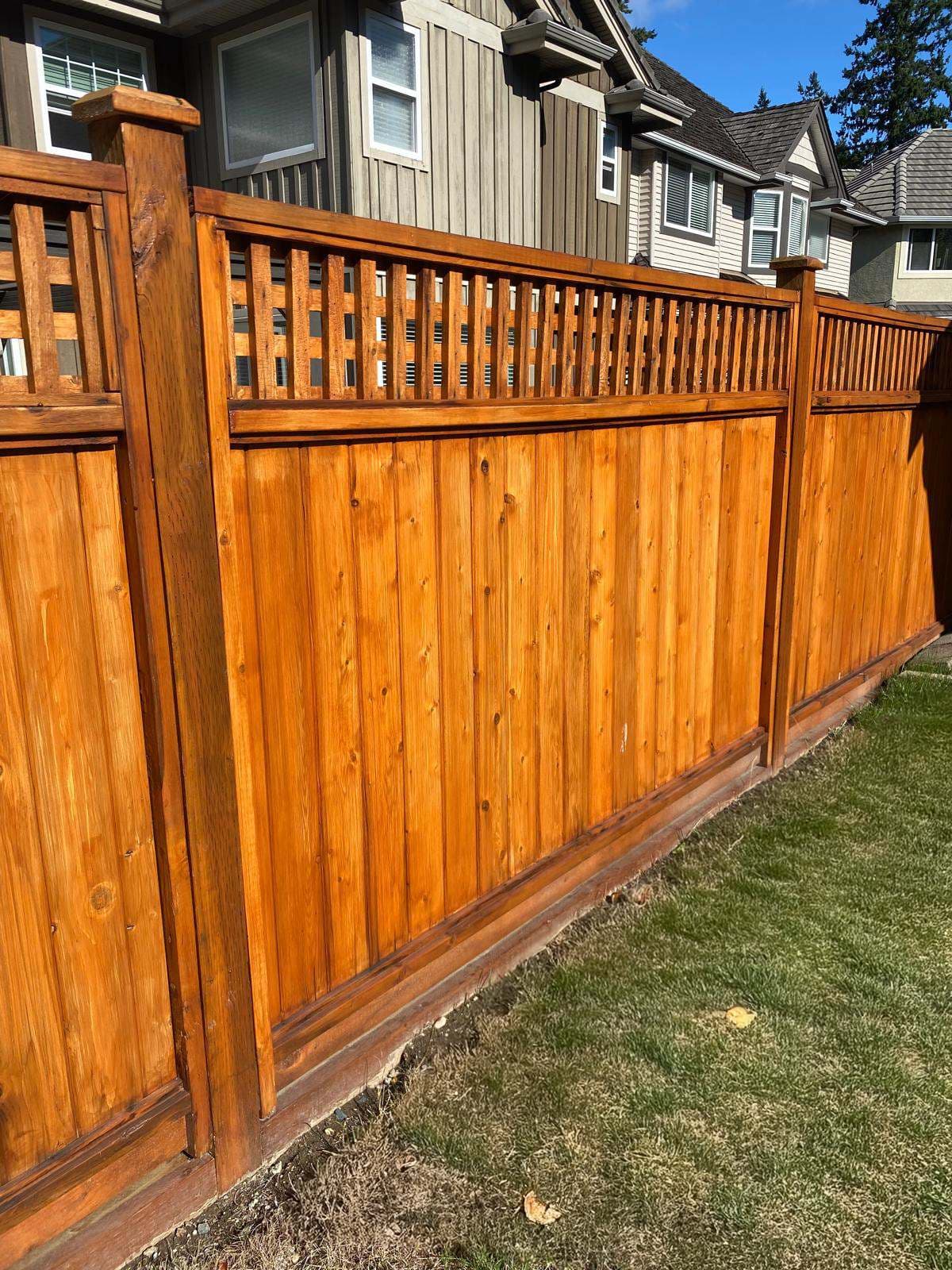 Stained cedar privacy fence with an open vertical-slat top