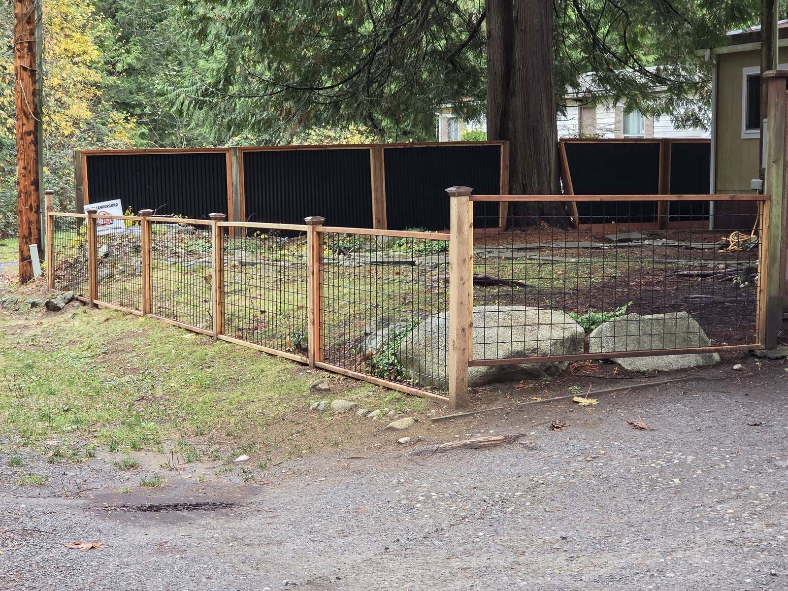 Cedar-framed wire mesh fence with wood and steel panels behind