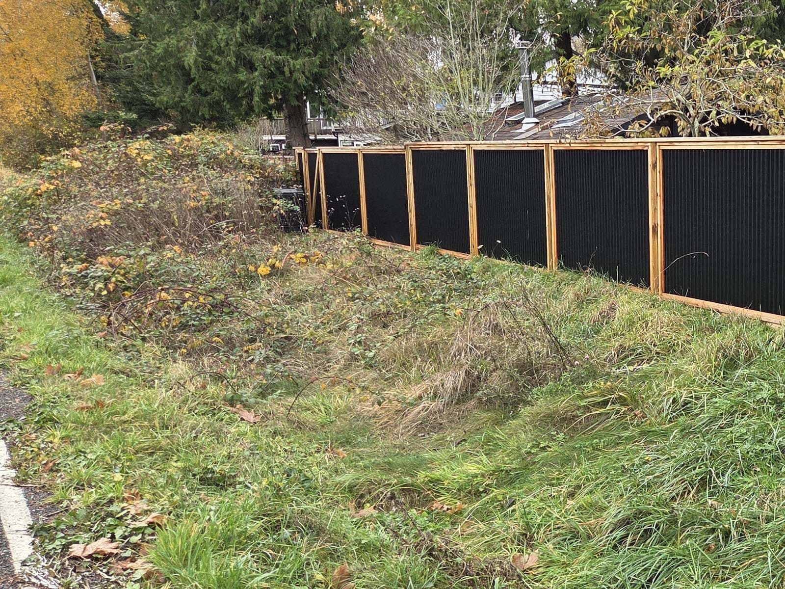 Wood and steel fence line along a rural roadside