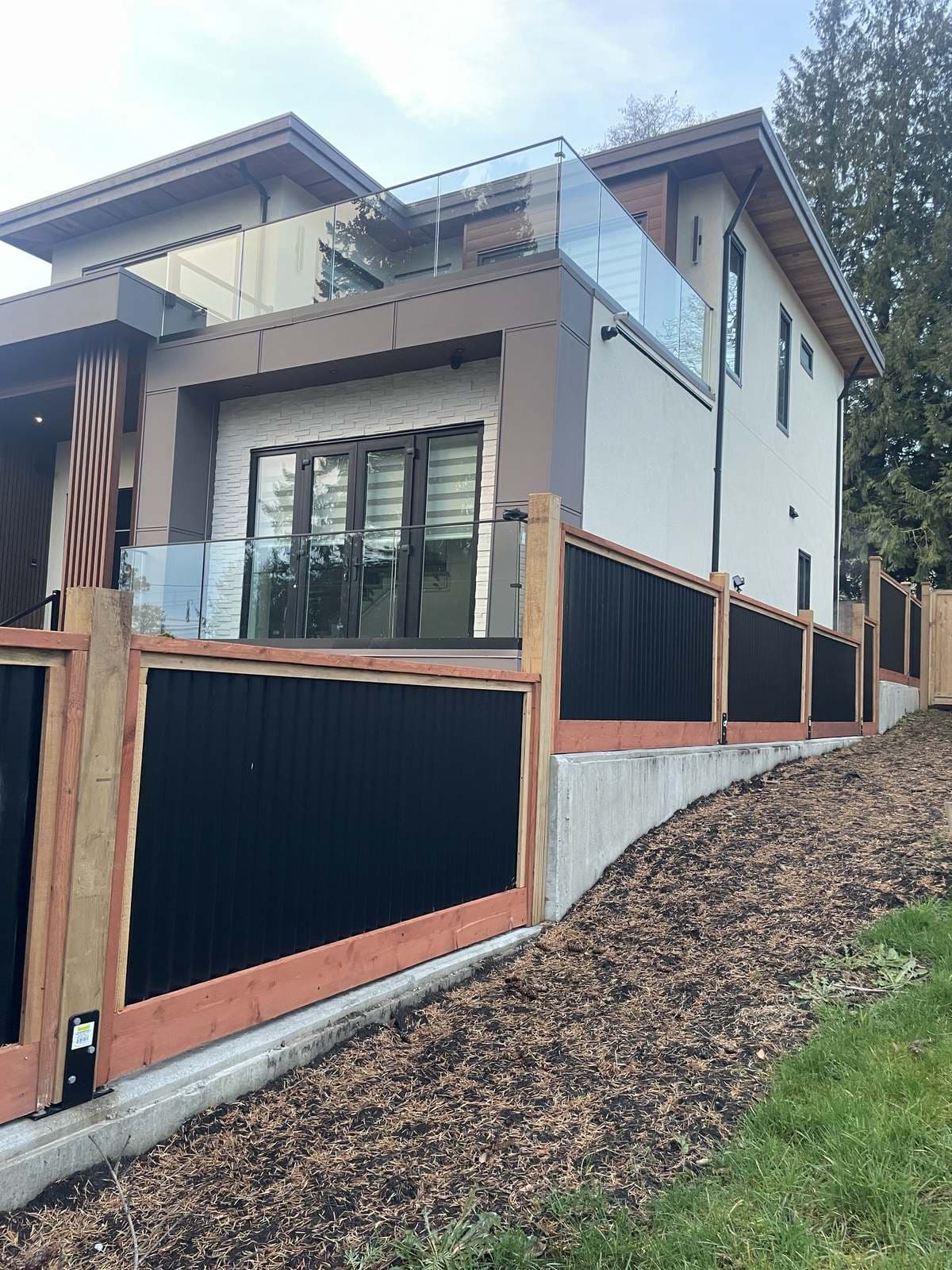 Wood and steel fence panels stepping up a raised concrete foundation wall