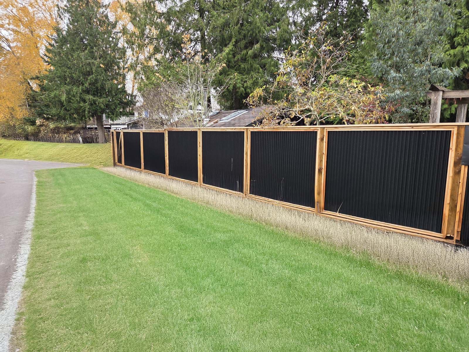 Long wood and steel fence run beside a walking path