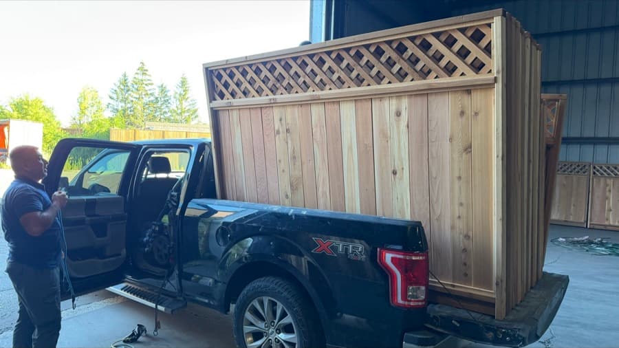 Fence panels being loaded onto a customer pickup truck at the yard
