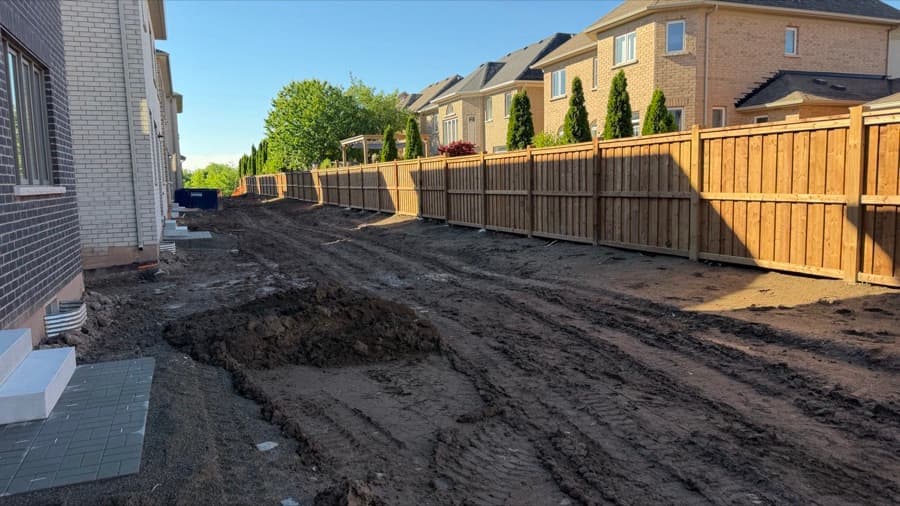 Brown pressure-treated privacy fence installed along new-build homes